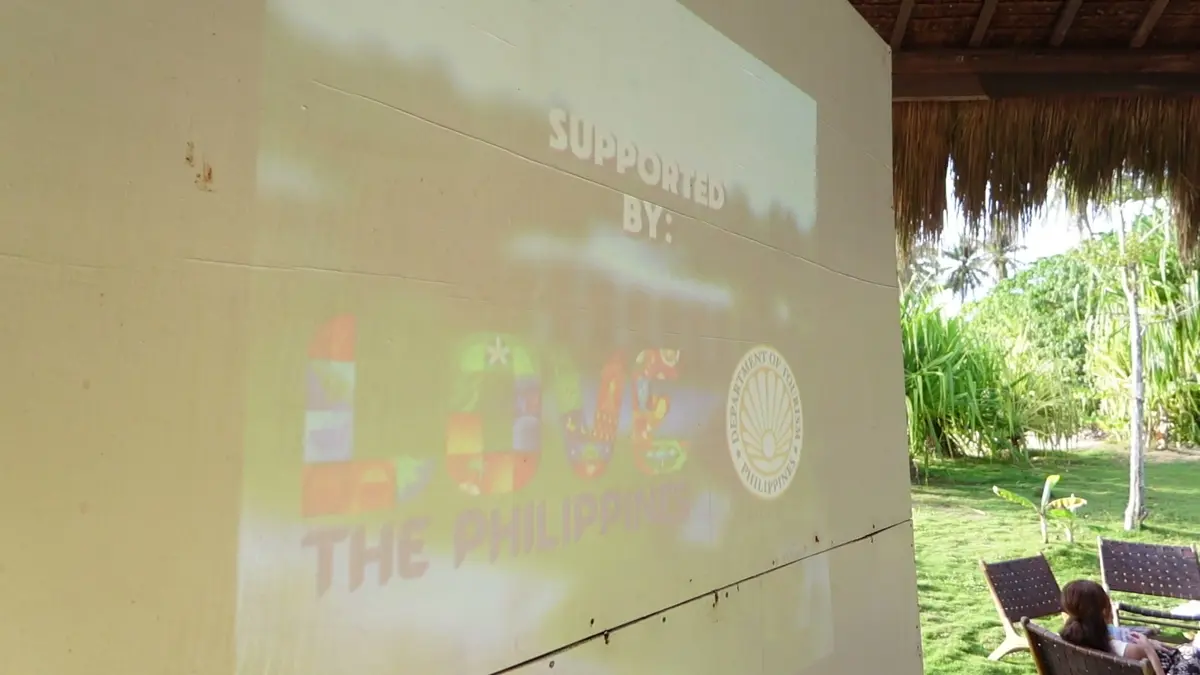 A projected screen reading Supported by, with partner logos